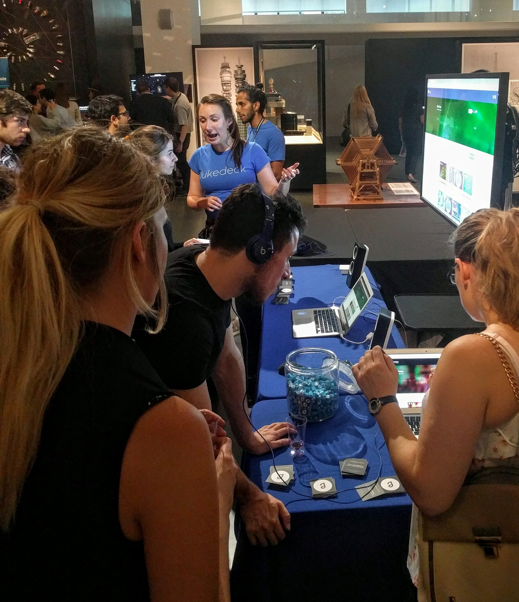 Lydia and me (in the background) explaining what Jukedeck and its technology is about to curious visitors at our stall.
